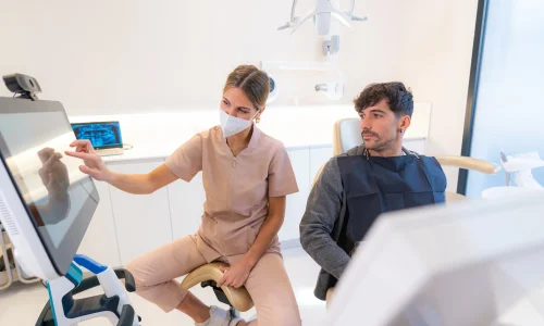 dentist-showing-3d-image-to-patient-sitting-on-a-c-2024-12-10-00-53-35-utc